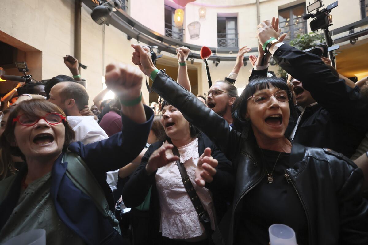 A crowd of people raise fisted hands 