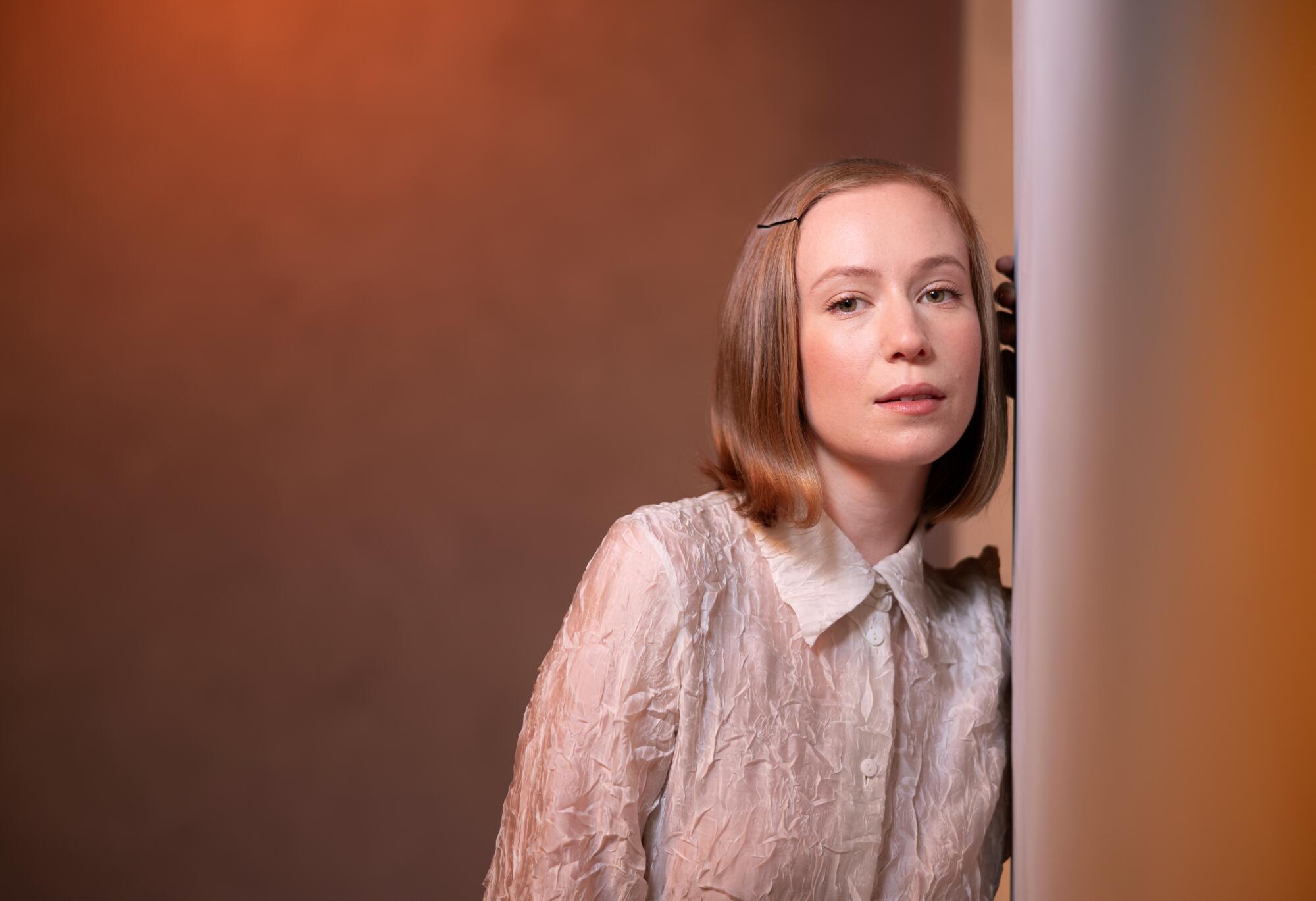 Hannah Einbinder leans against a wall for a portrait.