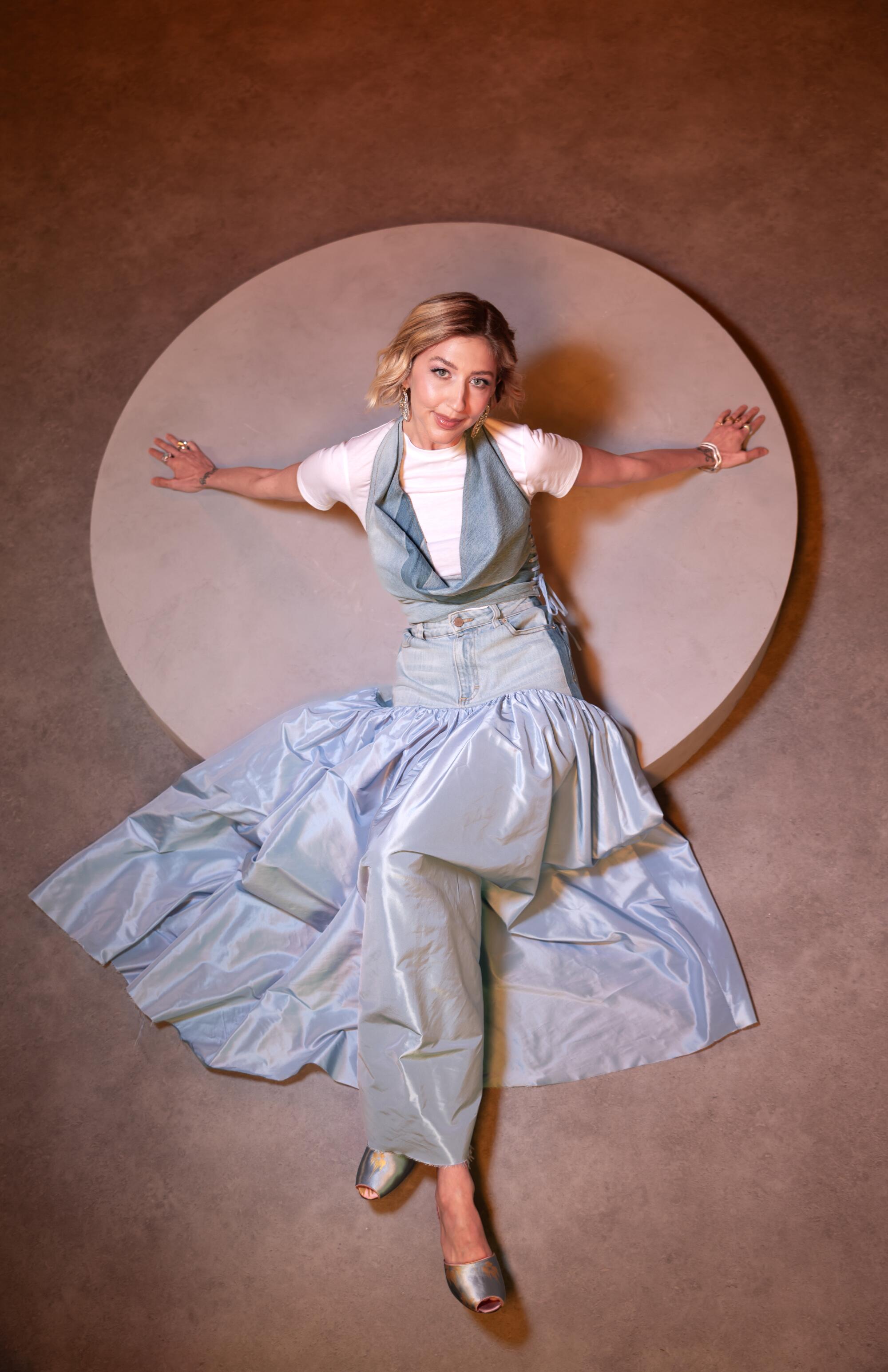 Heidi Gardner leans back on a raised platform and is shot from above.