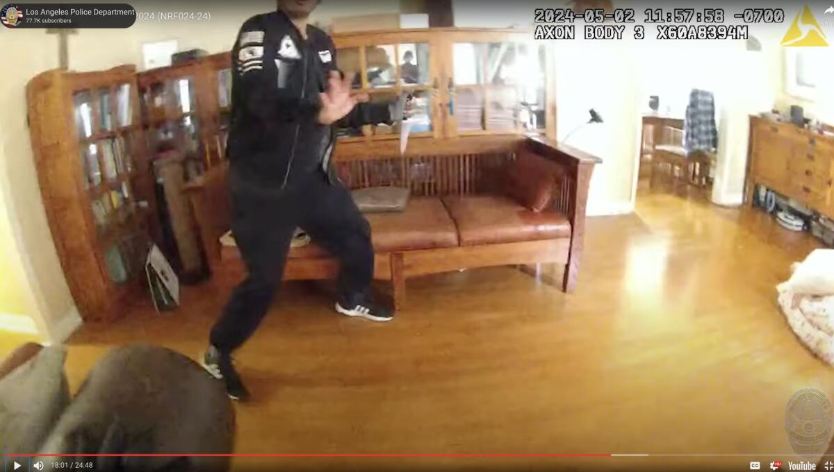 A still from an officer's body camera footage shows a man holding a knife in his family's home