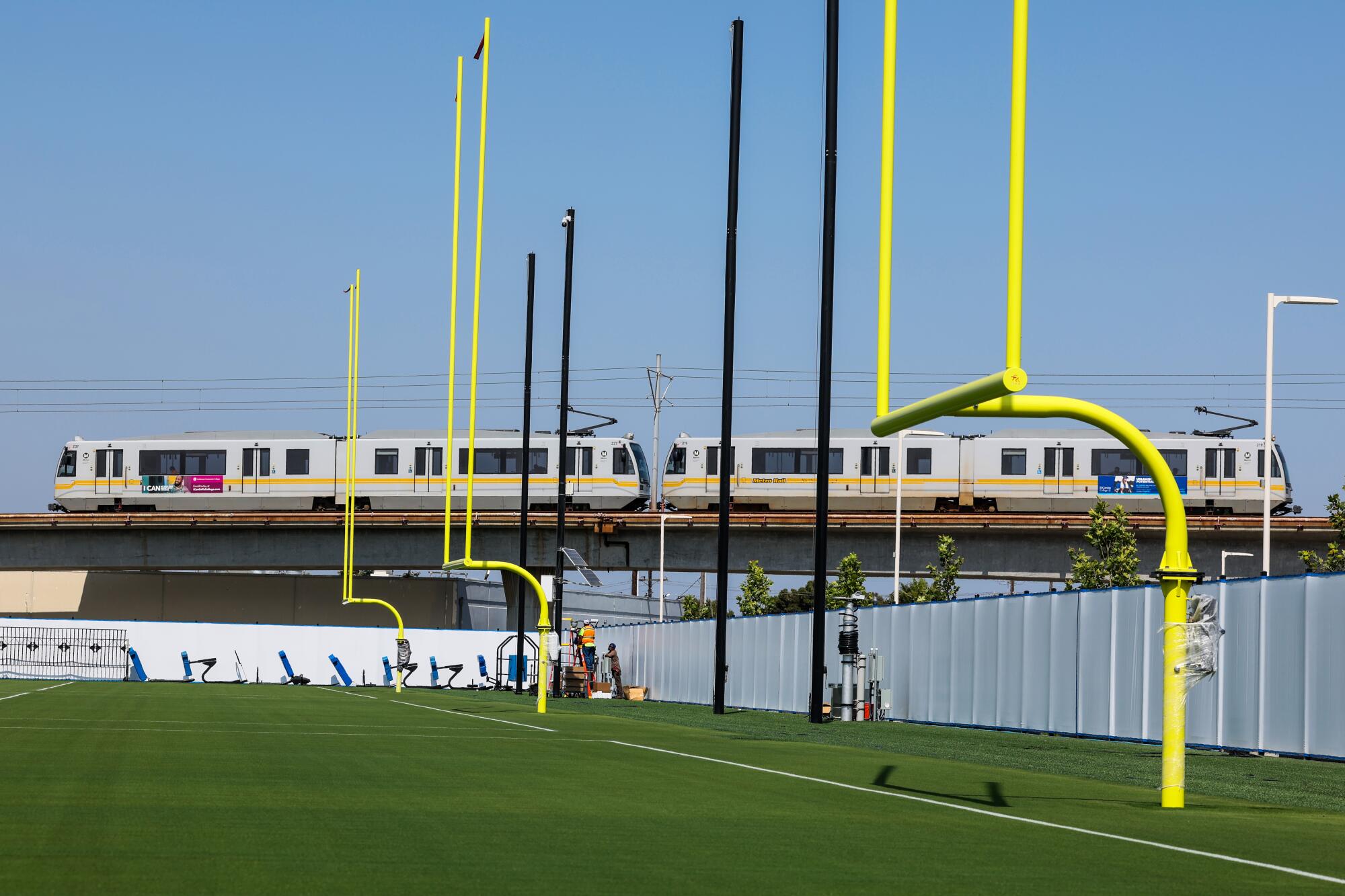 A train runs by the Chargers practice field.