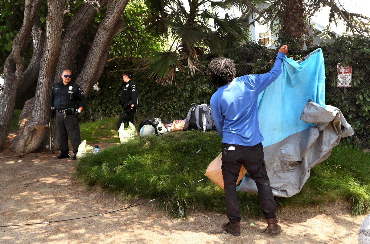 A homeless man breaks down his tent at Venice Corner Ball Park in Venice.