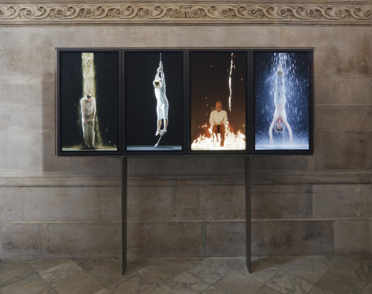 A video polyptych on four plasma displays show human personifications of earth, air, fire and water.