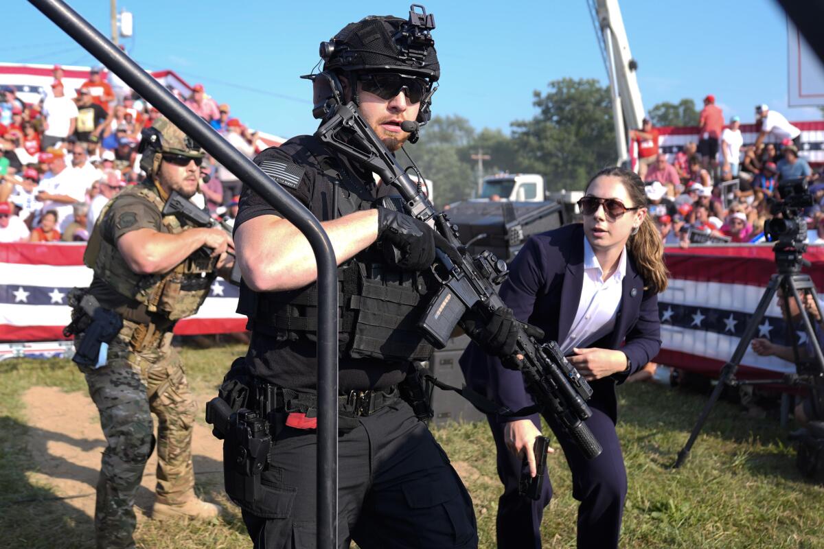 Secret Service agents respond as former President Trump is surrounded on stage at a campaign rally in Butler, Pa.