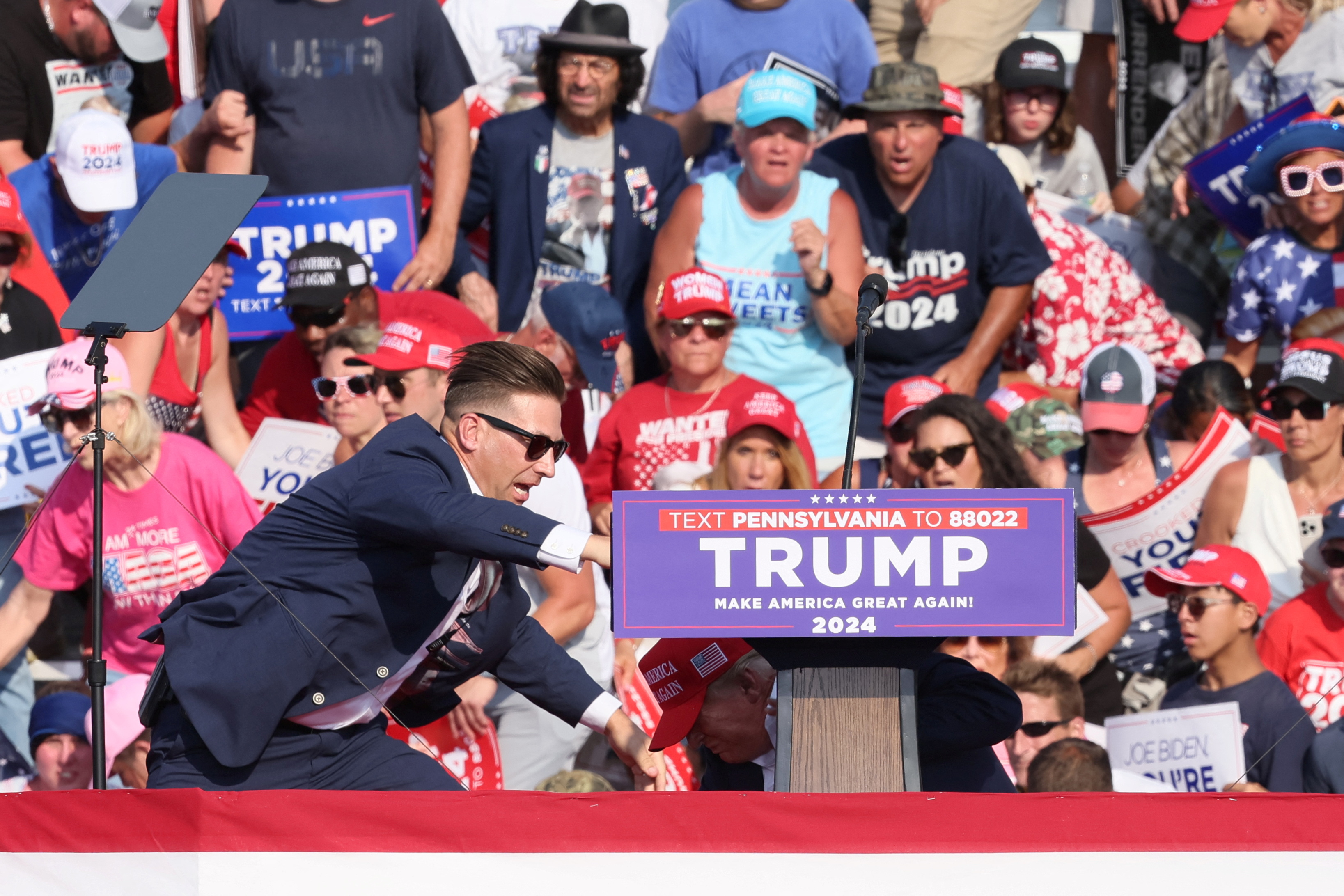 Republican presidential candidate and former U.S. President Donald Trump and security personnel react as multiple shots rang out