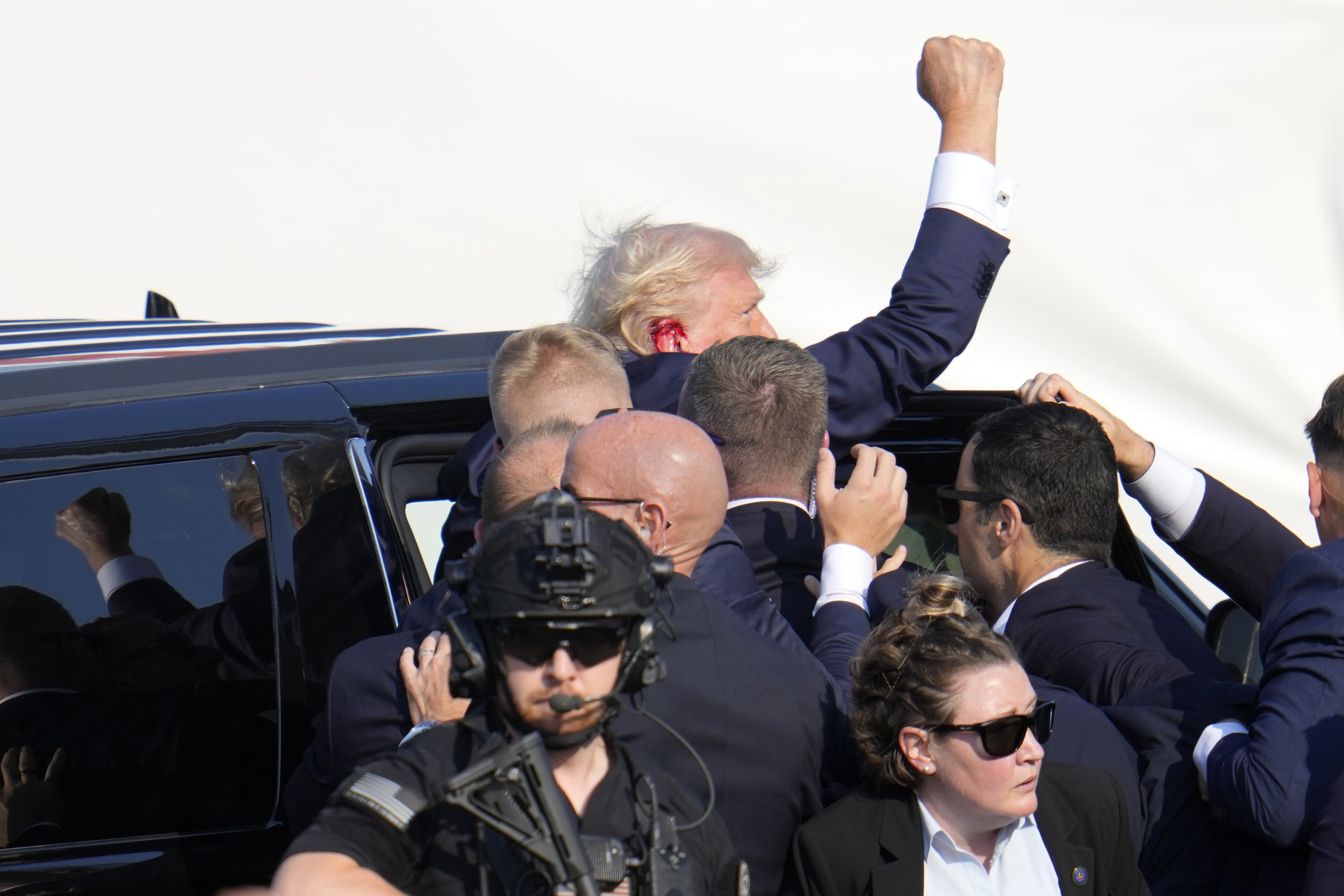 Trump was rushed to his car as he held his fist high