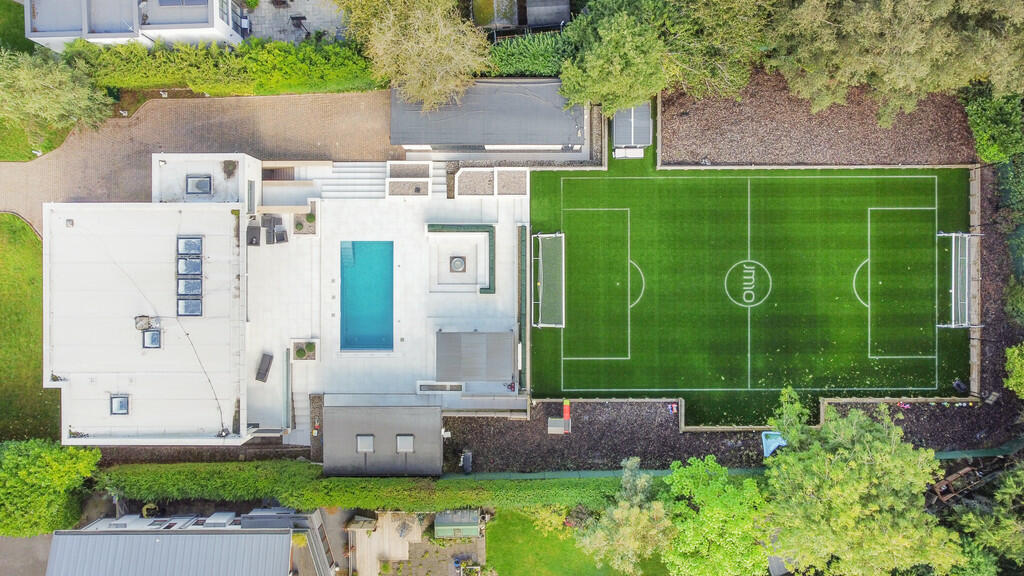 The property features a stunning pool and full-sized football pitch