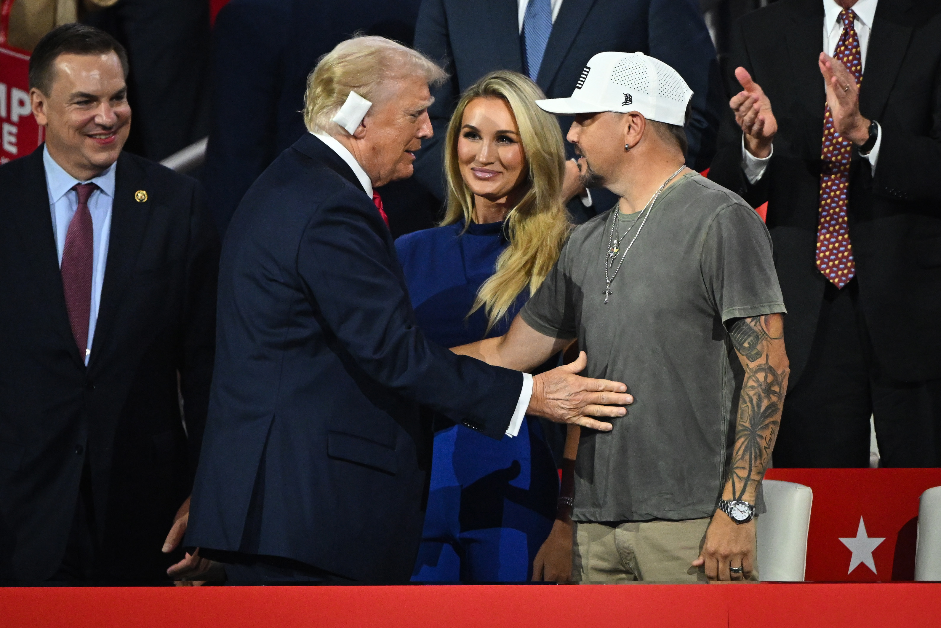 Republican presidential candidate, former U.S. President Donald Trump greets country music artist Jason Aldean (R) and his wife, Brittany Aldean (C)