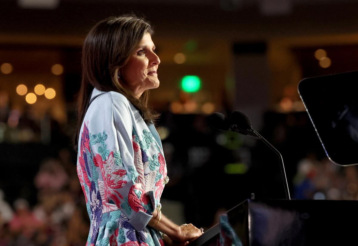 Former Ambassador Nikki Haley stands at a dais.