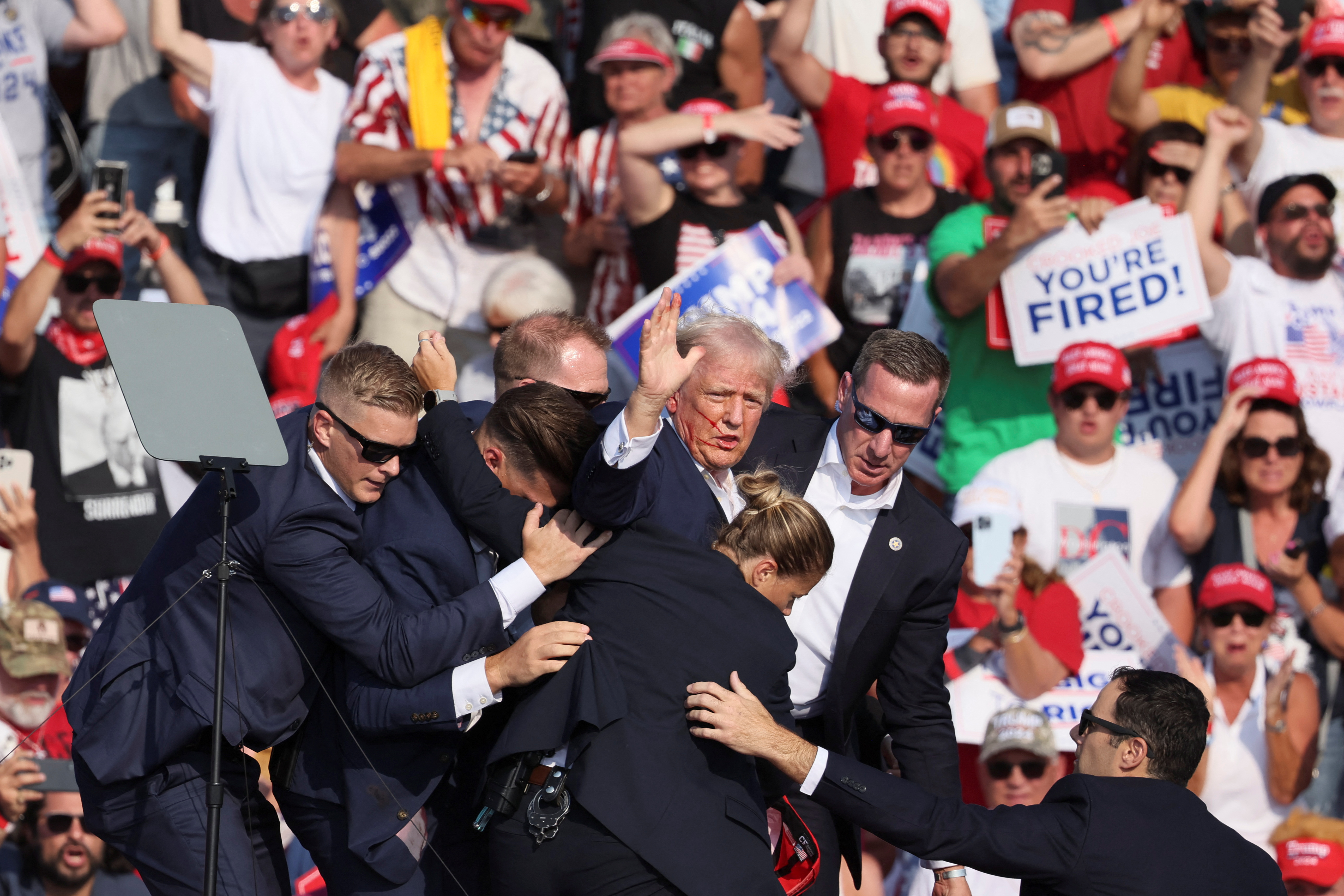 Former U.S. President Donald Trump waves to the crowd after being shot