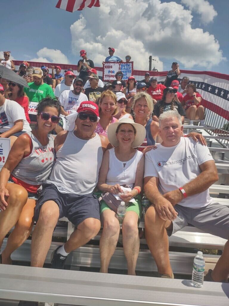 Pictured L to R: Jodine Downey, Mike Costanzo, Lori Bliss (in pink top at the back), Rosemary Costanzo (in the hat), Jeanine Wiggins and Chuck Wiggins sit at the Trump rally in Butler, Pennsylvania