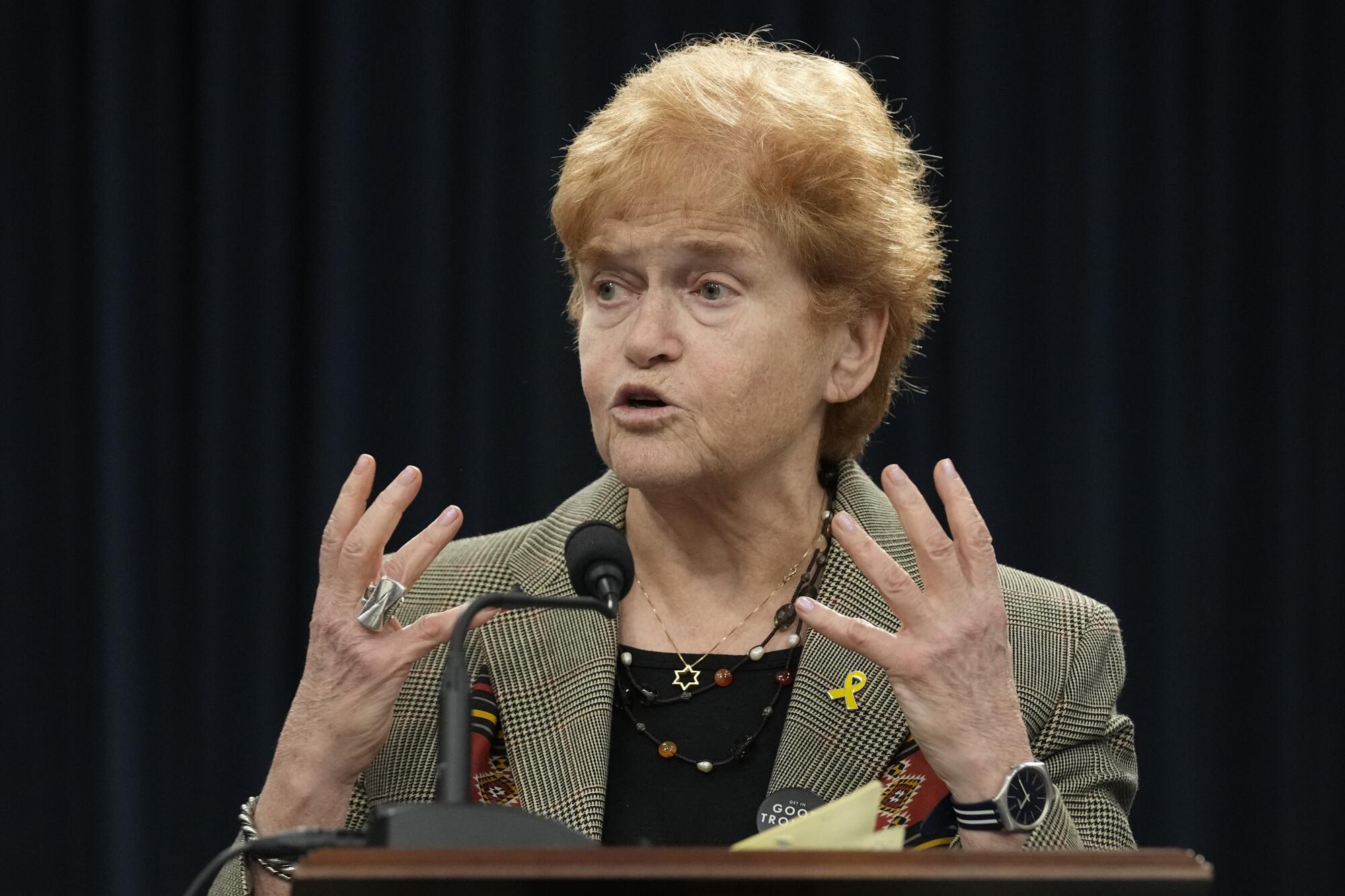 Deborah Lipstadt gestures with her hands while speaking at a lectern