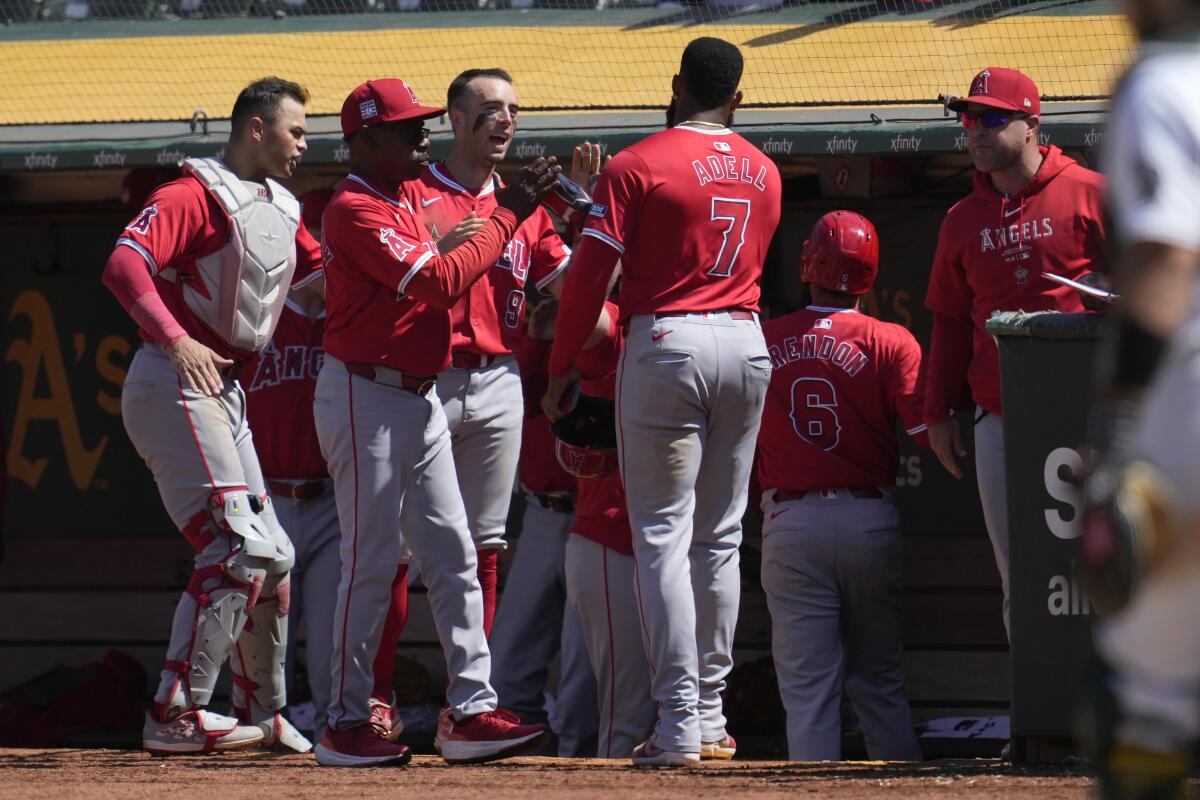 Los Angeles Angels' Jo Adell (7) is congratulated by manager Ron Washington.