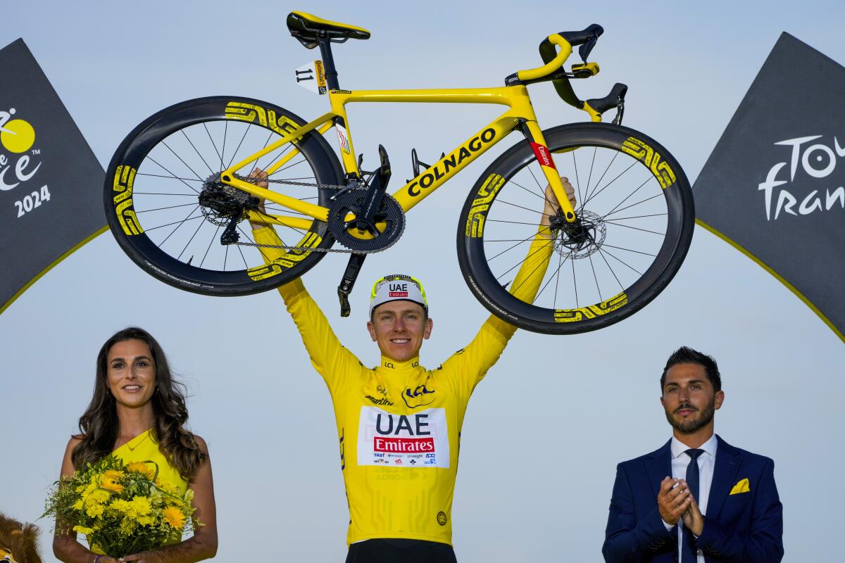 Tadej Pogacar celebrates on the podium after winning the Tour de France on Sunday.