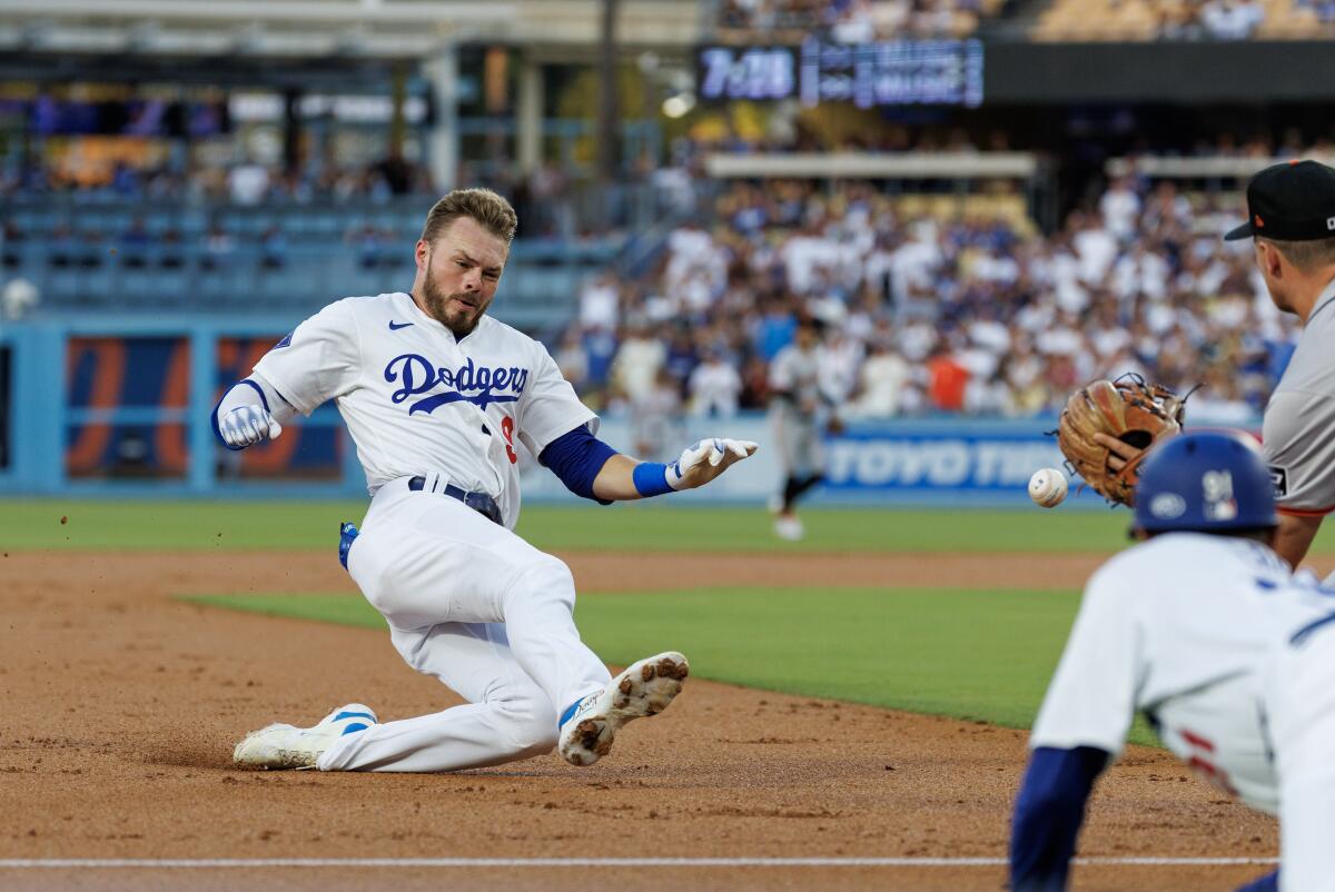 The Dodgers' Gavin Lux slides in front of Giants third baseman Matt Chapman.