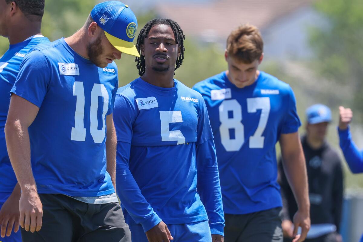 Rams Cooper Kupp, Tutu Atwell and Davis Allen converse on the practice field sideline.