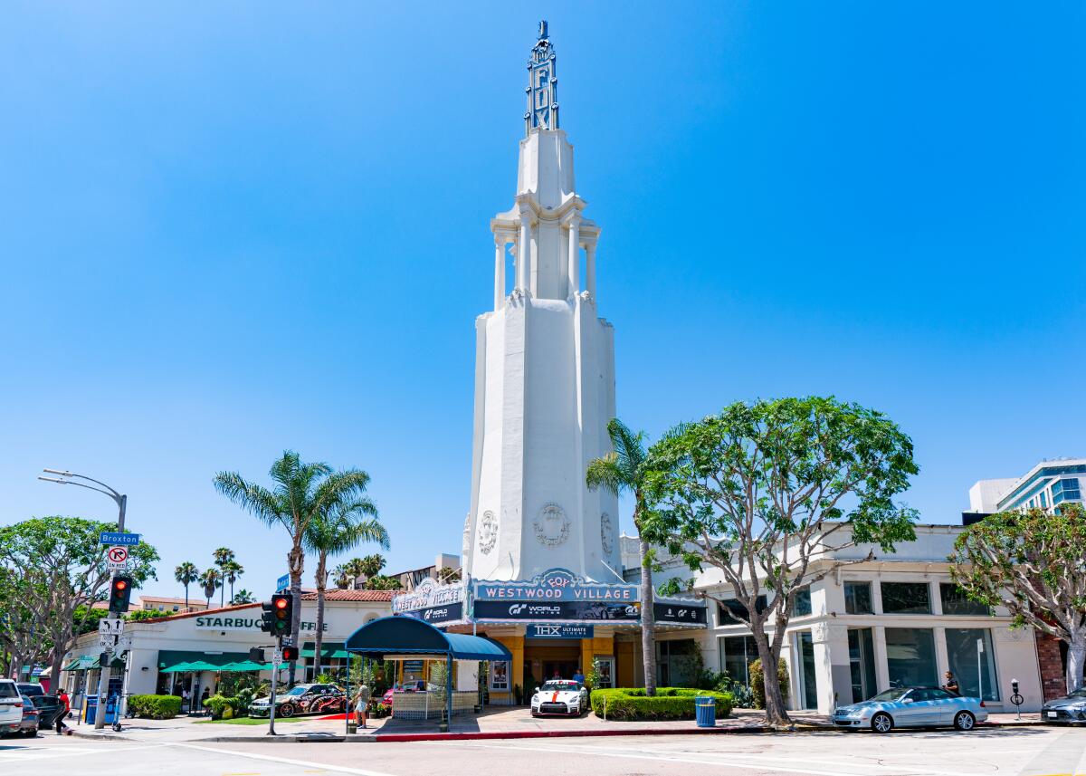 A tall white tower atop a movie theater