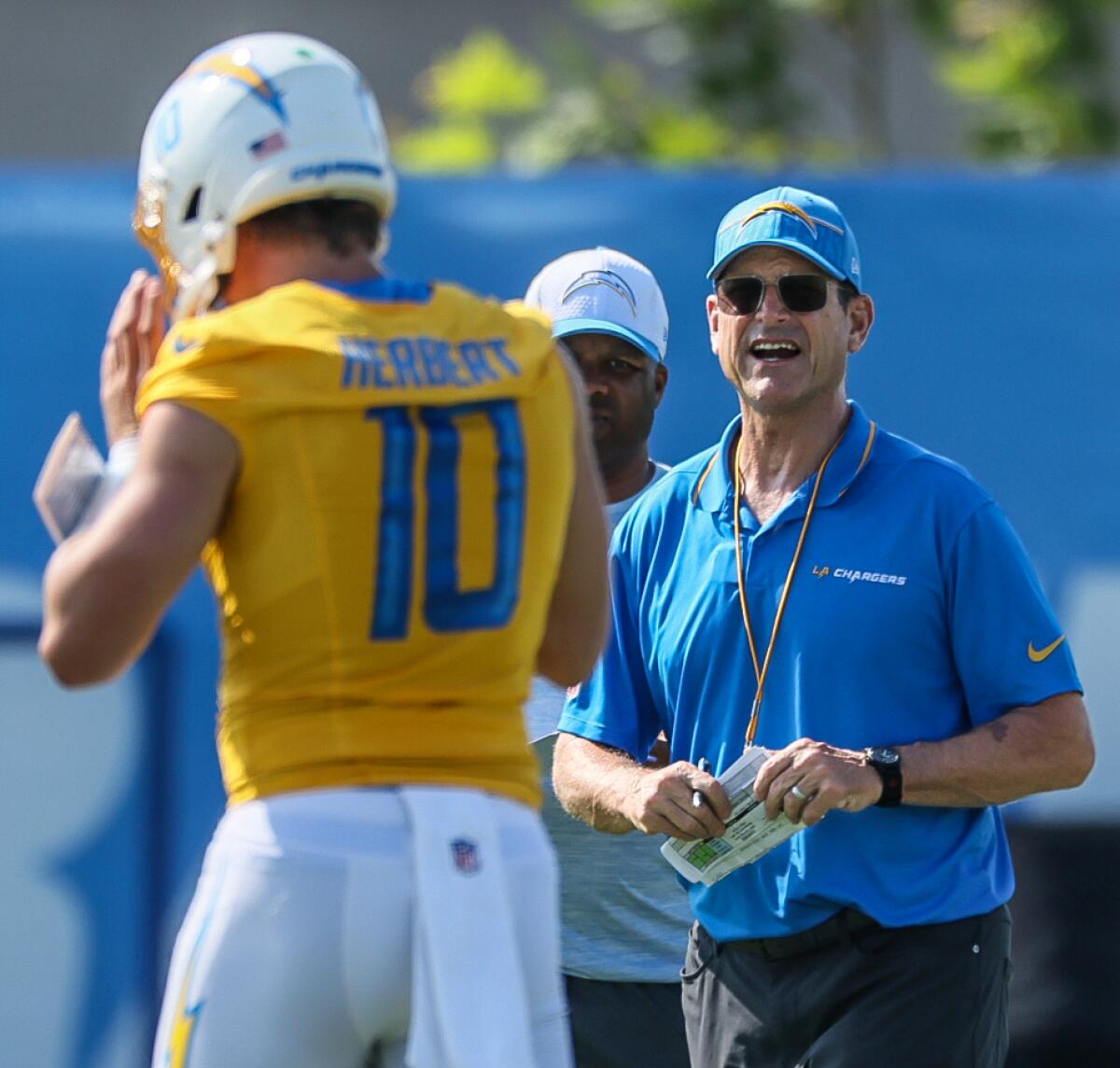 Chargers coach Jim Harbaugh talks with quarterback Justin Herbert during training camp Wednesday in El Segundo.