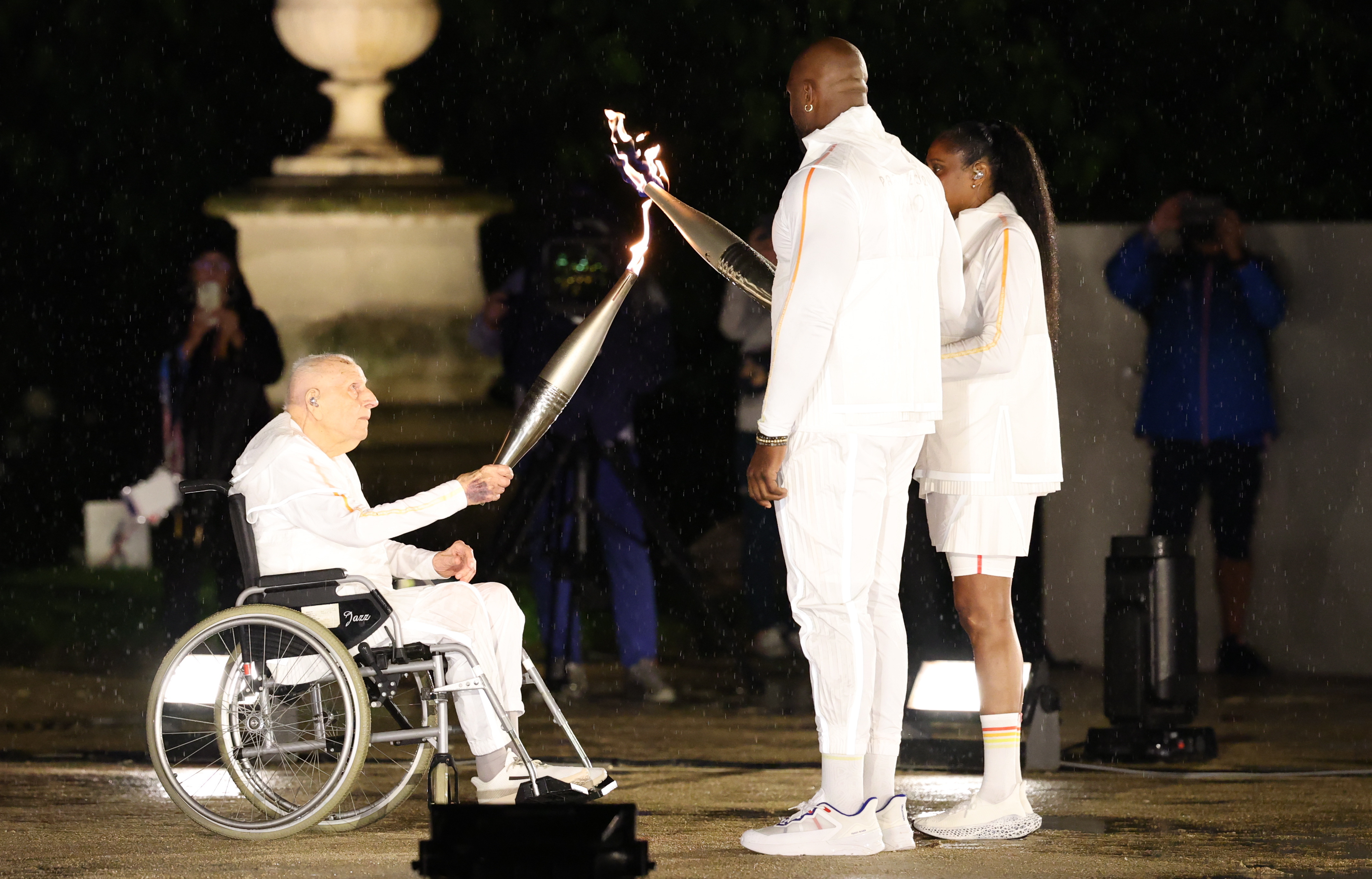 Teddy Riner and Marie-Jose Perec light their Olympic torches