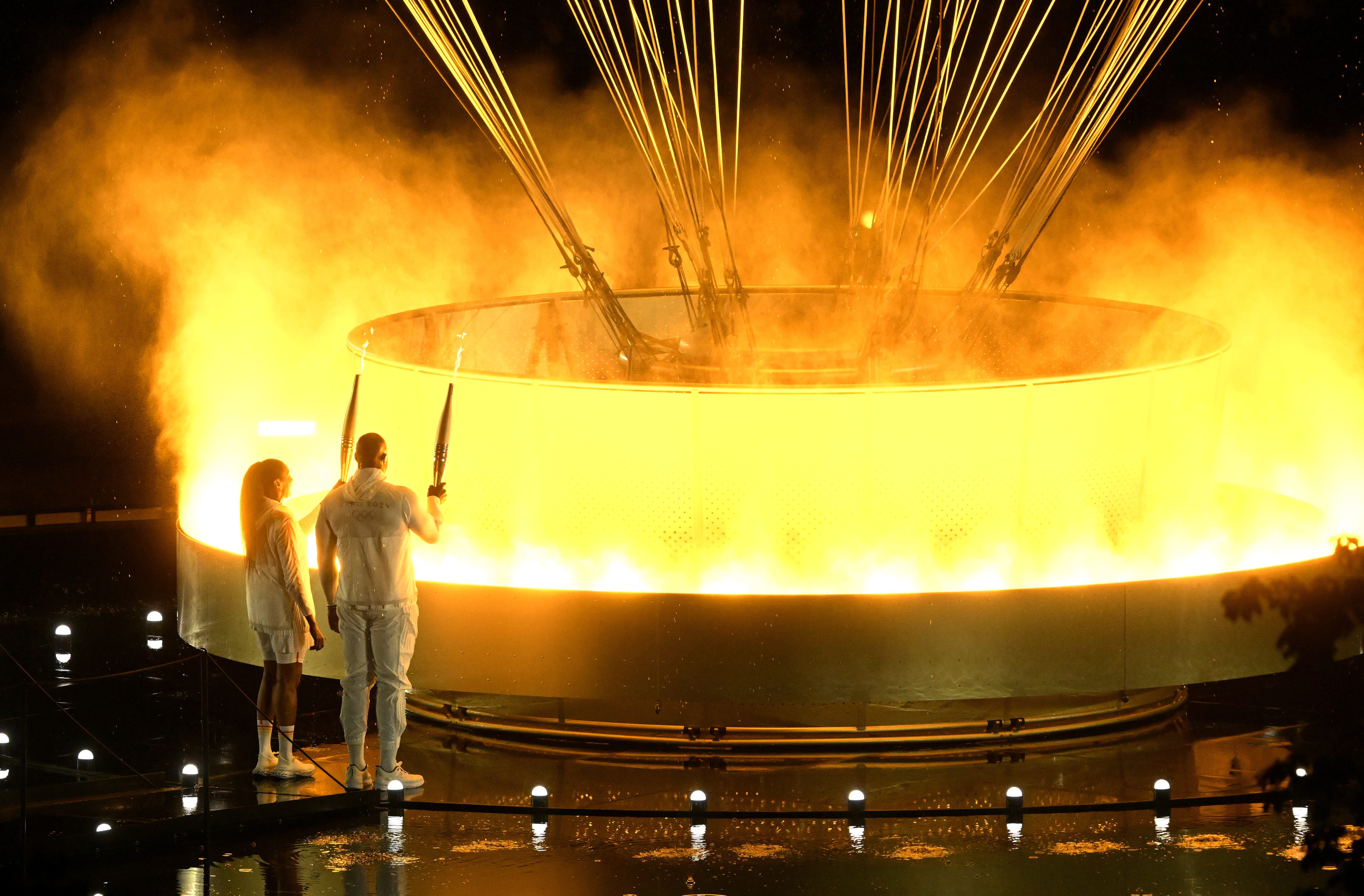 Riner and Perec's flames light up an Olympic cauldron