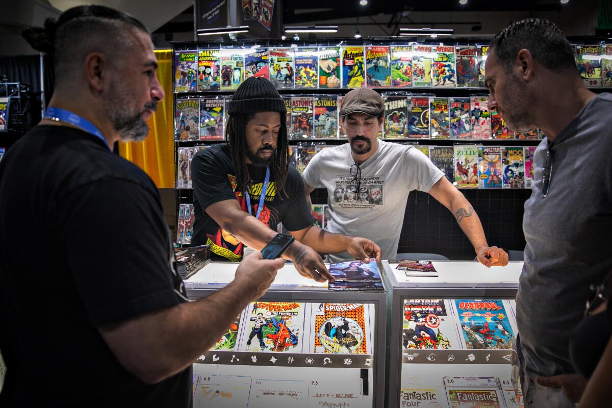 Four men stand around a counter at a comic book shop