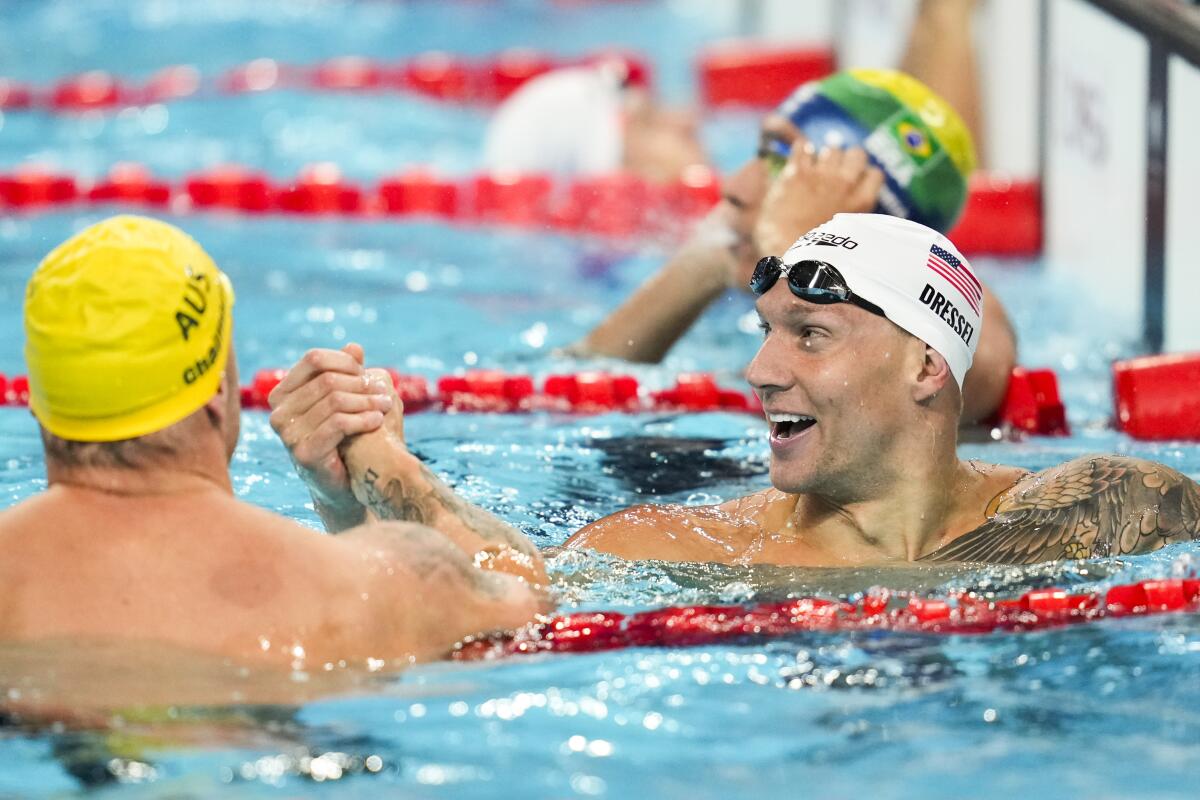 American Caeleb Dressel, right, shakes the hand of Australian Kyle Chalmers after a men's 400-meter freestyle relay heat.