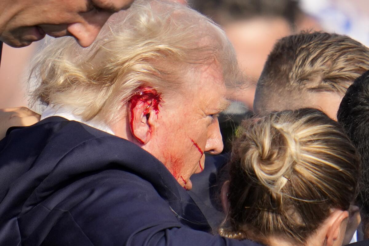 Former President Trump is escorted to a motorcade following an attempted assassination in Butler, Pa., on July 13.