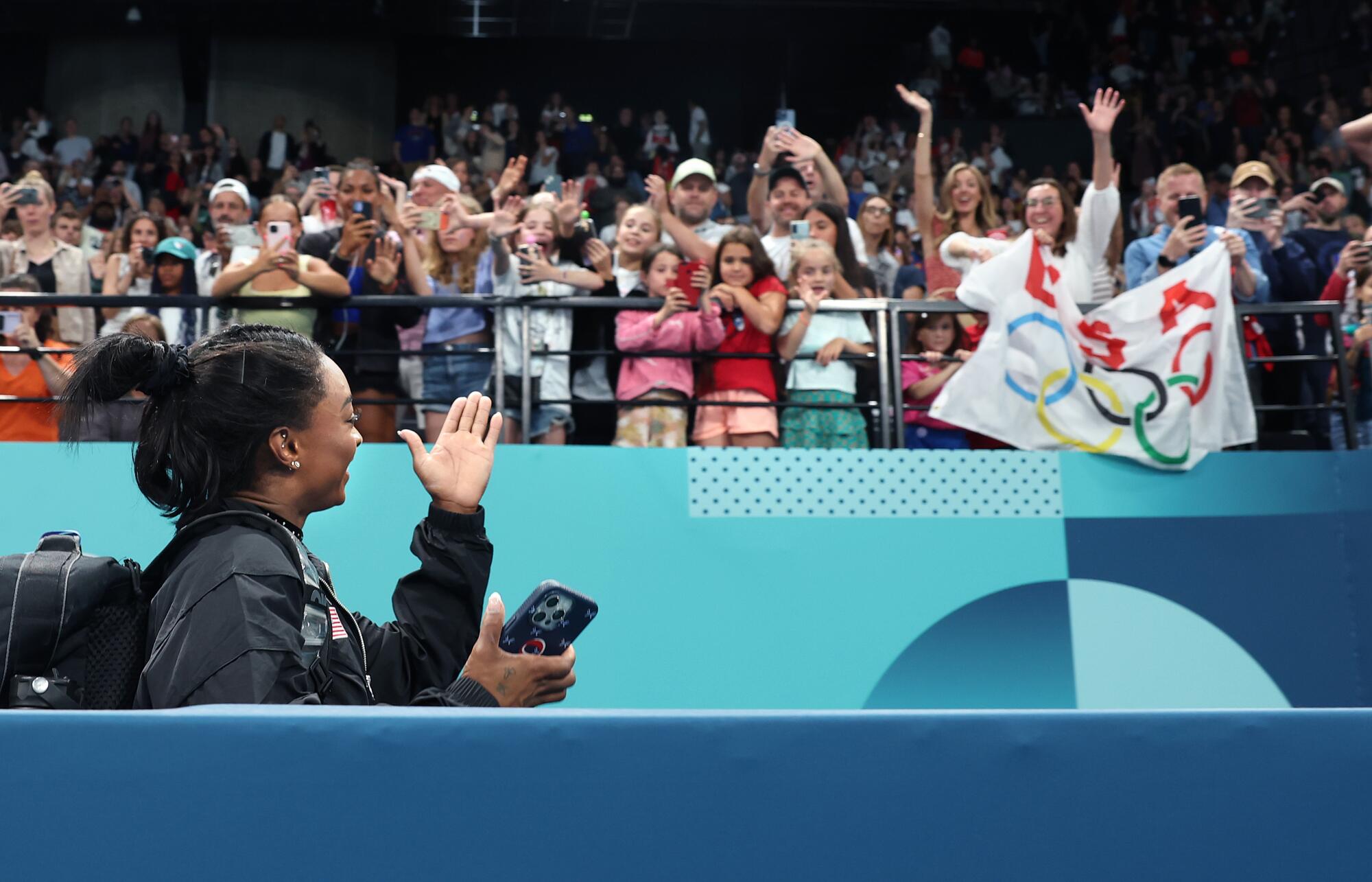 U.S. gymnast Simone Biles waves to fans after women's gymnastics qualifications at the Paris Olympics on Sunday.