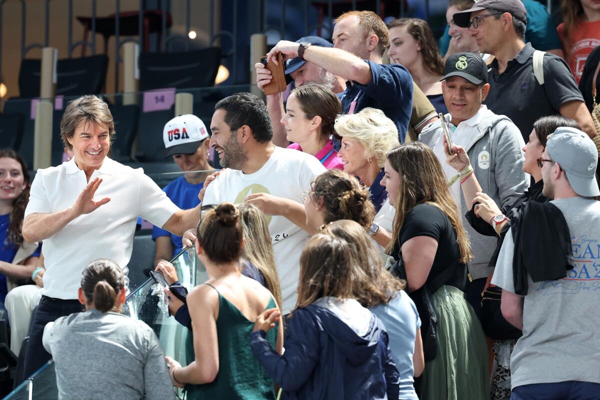 Actor Tom Cruise greets fans before women's gymnastics team qualifying at the Paris Olympics.