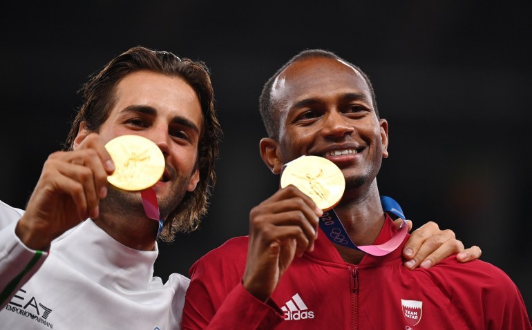 Tokyo 2020 Olympics - Athletics - Men's High Jump - Medal Ceremony - Olympic Stadium, Tokyo, Japan – August 2, 2021. Gold medallists, Gianmarco Tamberi of Italy and Mutaz Essa Barshim of Qatar pose as they celebrate on the podium REUTERS/Dylan Martinez