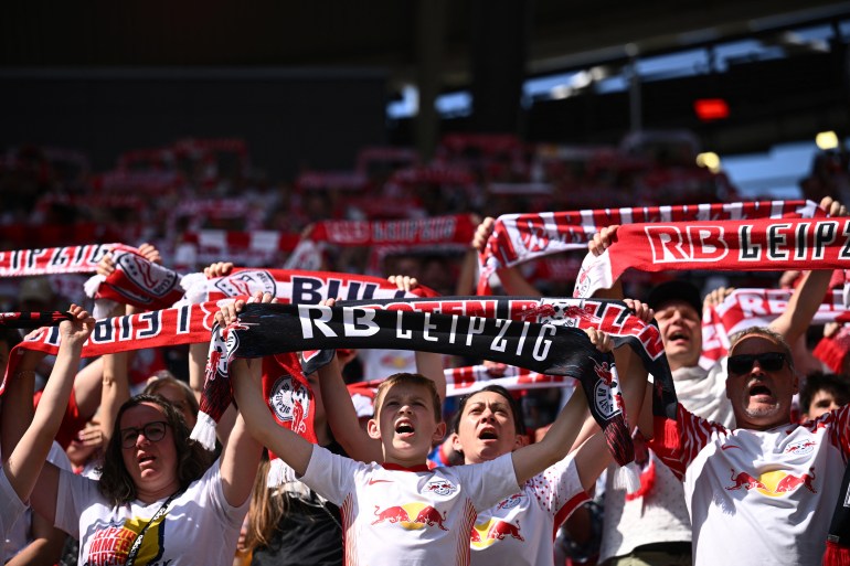 Spectators at football match holding banners.