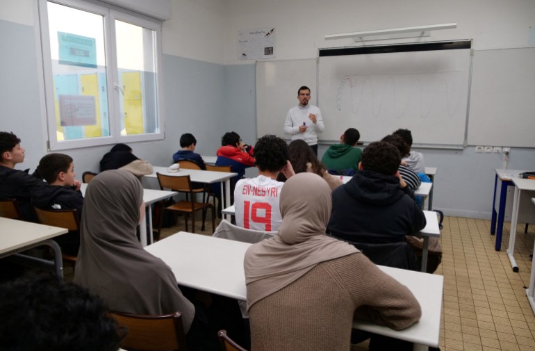 Middle school students, some wearing a hijab, listen to teacher Ilyas Laarej during an Islamic ethics class at the Averroes school, France's biggest Muslim educational institution