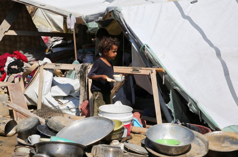 A child walks amid damage following an Israeli strike at a tent camp in Al-Mawasi area, amid Israel-Hamas conflict, in Khan Younis in the southern Gaza Strip July 13, 2024. REUTERS/Hatem Khaled