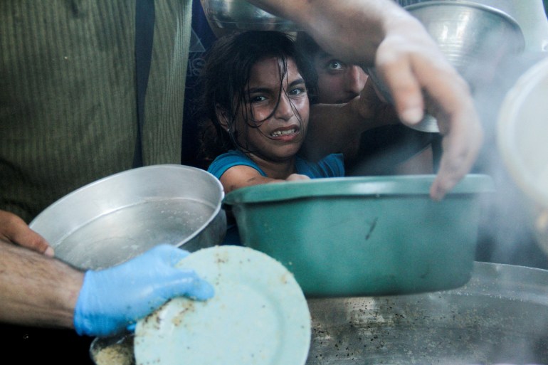 Palestinian children gather to receive food cooked by a charity kitchen, amid food scarcity, as Israel-Hamas conflict continues, in the northern Gaza Strip, July 18, 2024. REUTERS/Mahmoud Issa TPX IMAGES OF THE DAY