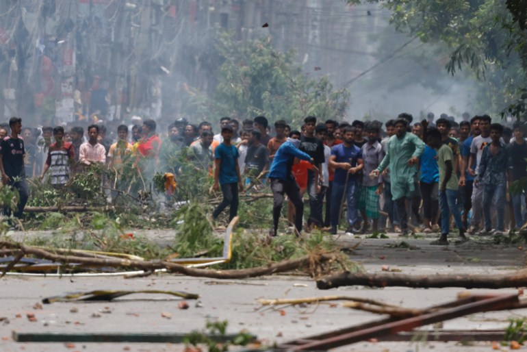 A demonstrator throws an object as protesters clash with Border Guard Bangladesh (BGB) and the police outside the state-owned Bangladesh Television as violence erupts across the country after anti-quota protests by students