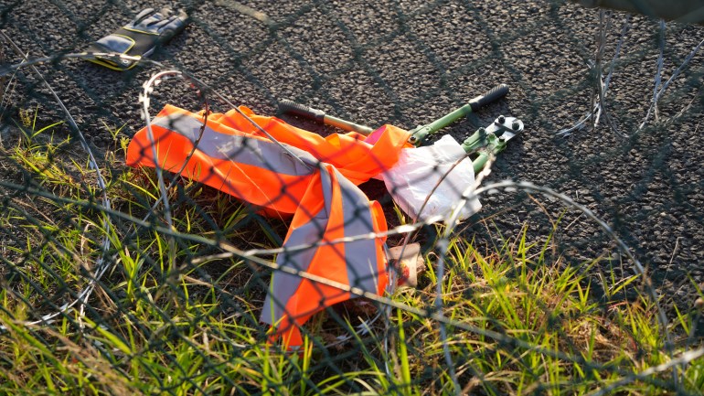 Tools lay on the ground after activists of the "Letzte Generation" (Last Generation) cut a hole in a fence and staged a demonstration near the runways at the airport in Frankfurt,