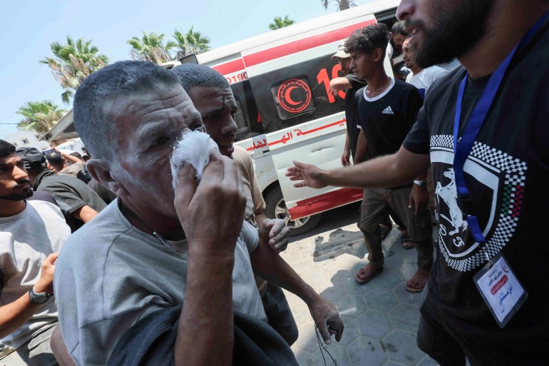 An injured Palestinian man covers his face at Al-Aqsa Martyrs Hospital