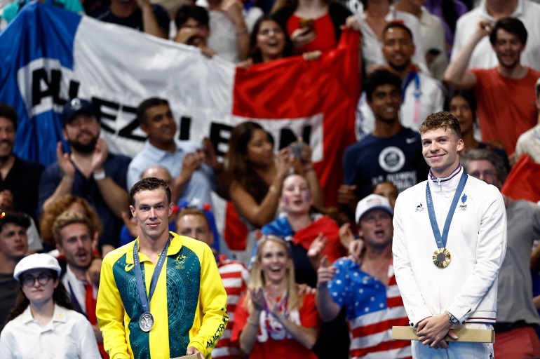 Paris 2024 Olympics - Swimming - Men's 200m Breaststroke Victory Ceremony - Paris La Defense Arena, Nanterre, France - July 31, 2024. Gold medallist Leon Marchand of France celebrates on the podium with silver medallist Zac Stubblety-Cook of Australia. REUTERS/Clodagh Kilcoyne