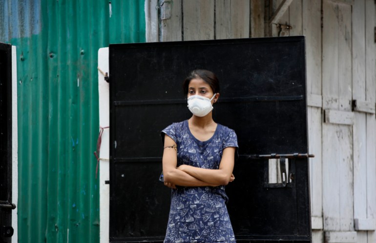 A woman watches health workers pick up relative who has been diagnosed as COVID-19 in Gauhati, India, Saturday, July 4, 2020. India's number of coronavirus cases passed 600,000 on Thursday with the nation's infection curve rising and its testing capacity being increased. More than 60% of the cases are in the worst-hit Maharashtra state, Tamil Nadu state, and the capital territory of New Delhi. (AP Photo/Anupam Nath)