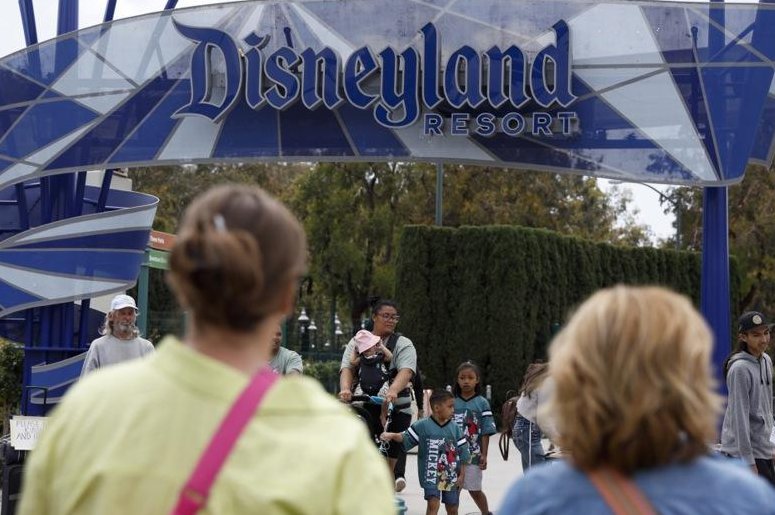 People walk towards a Disneyland Resort entrance in Anaheim, Calif., in May. Disneyland union workers on Friday began voting on a possible strike authorization. File Photo by Caroline Brehman/EPA-EFE