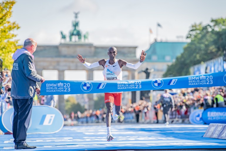 Runner passes finish line at marathon.