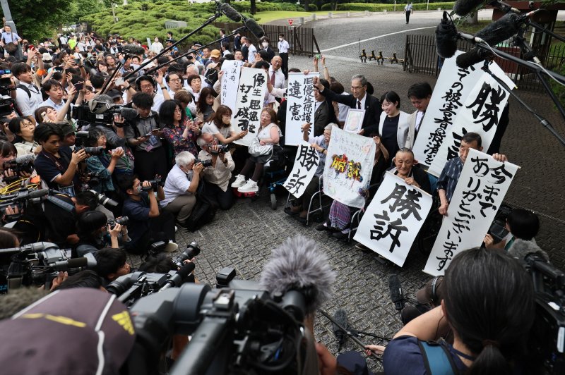 Plaintiffs hold up 'victory' banners as they celebrate outside Japan's Supreme Court in Tokyo after justices ruled sterilizations carried out decades ago under eugenics laws, some without victims' consent, violated their constitutional rights and that the government must pay out compensation. Photo by Jiji Press/EPA-EFE