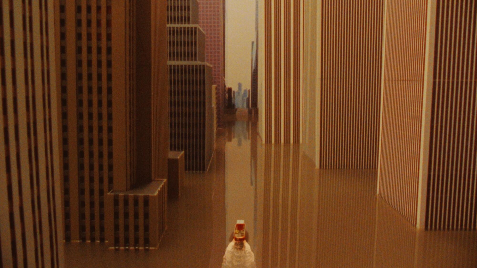 In a scene from Josh Kline's 16mm film "Adaptation," a tiny figure in the foreground stands between rows of skyscrapers.