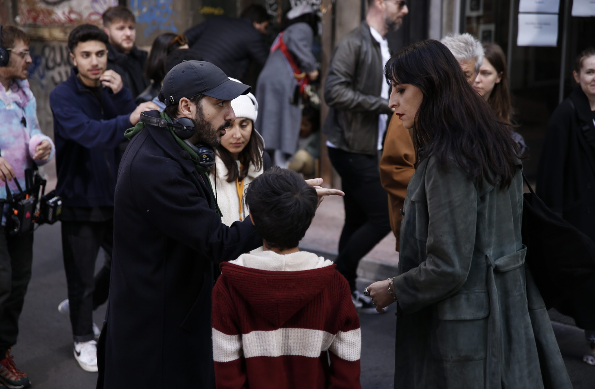 A director in a cap gives notes to his actors.