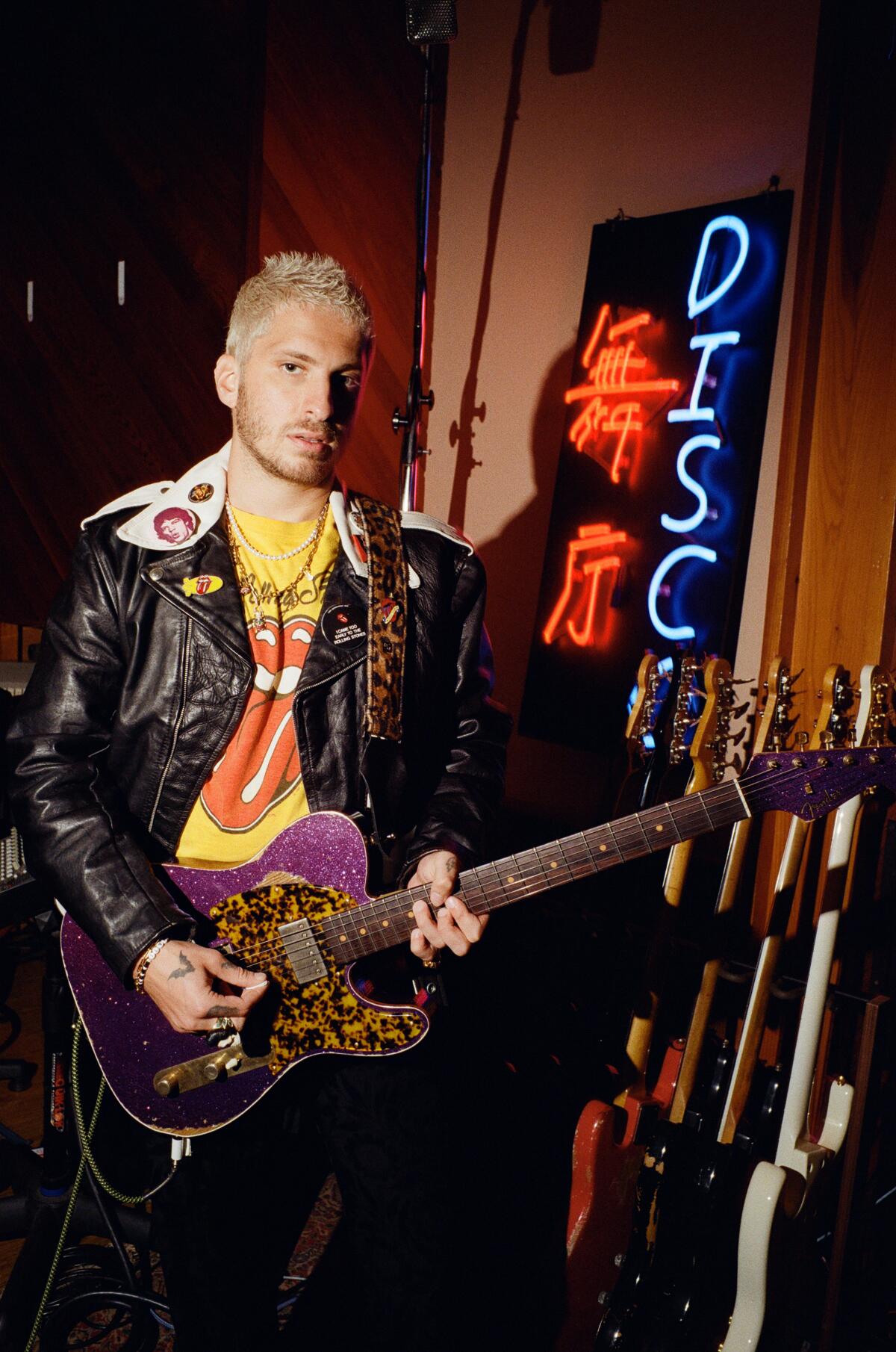 Man holding purple guitar