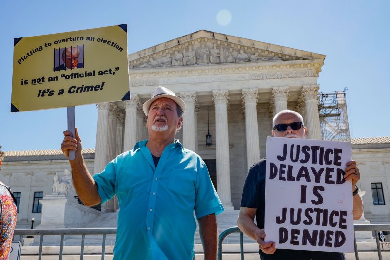 Gary Roush and Bill Christeson hold up signs outside of the Supreme Court prior to the courts decision to grant former president Donald Trump limited immunity in his Jan. 6 case at the U.S. Supreme Court on Monday. Photo by Jemal Countess/UPI