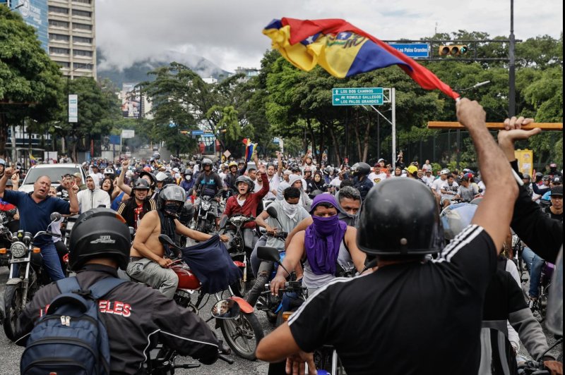 People ride through the streets on motorcycles during Monday's protest against the results of the presidential elections, in Caracas, Venezuela. According to the first report from the National Electoral Council (CNE), Venezuelan President Nicolas Maduro was re-elected for a third consecutive term in the elections held on Sunday. The opposition is calling for the release of the full vote count. Photo by Henry Chirinos/EPA-EFE