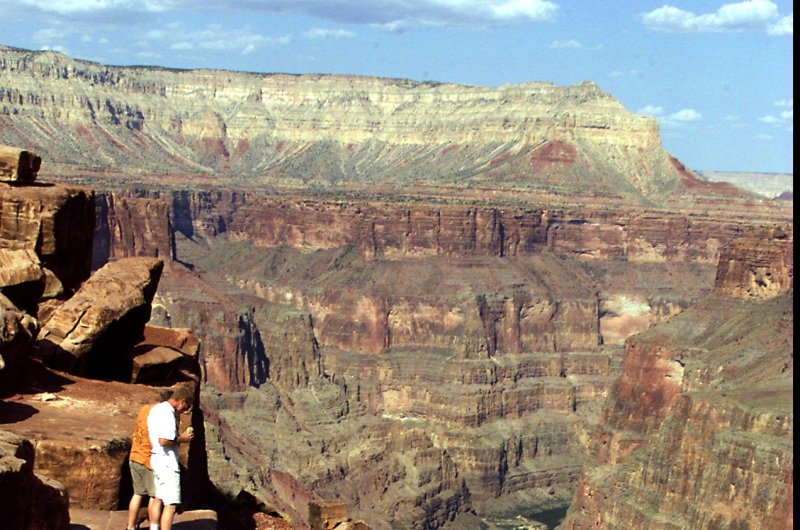 Tourists peer over the rim down to the Colorado River at Tuweep in the Grand Canyon National Park. Tuweep, accessible by a 60 mile dirt road, is visited by only about 12,000 people a year. Photo by Terry Schmitt UPI