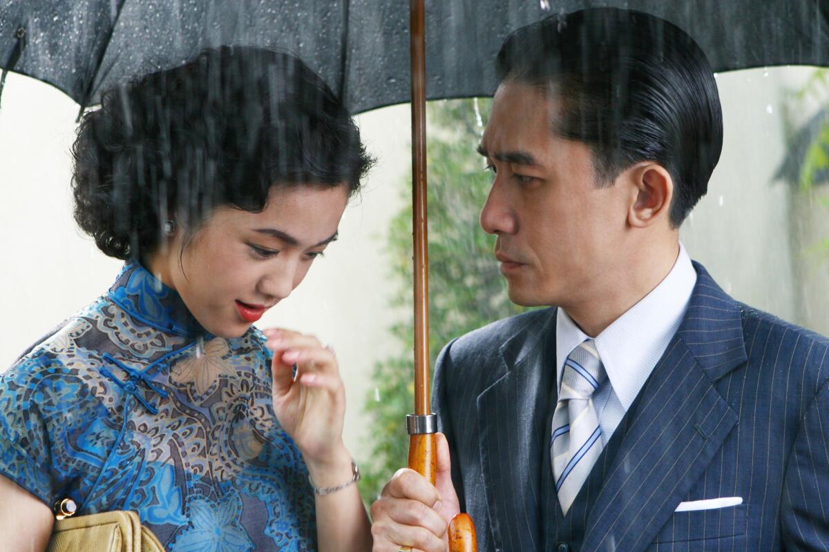 A man holds an umbrella for a woman.