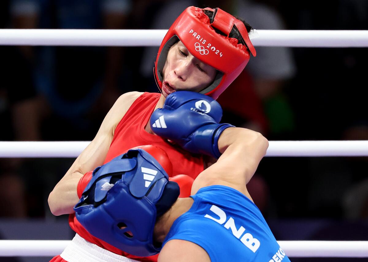 Taipei's Lin Yu Ting, red, takes a punch from Uzbekistan's Sitora Turdibekova in the Women's 57kg boxing match.